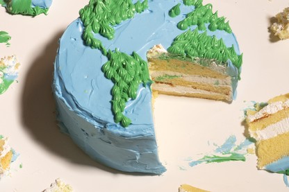 A cake decorated to look like earth from above with a large slice taken out and pieces scattered.