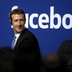 Mark Zuckerberg with the Facebook logo behind him 