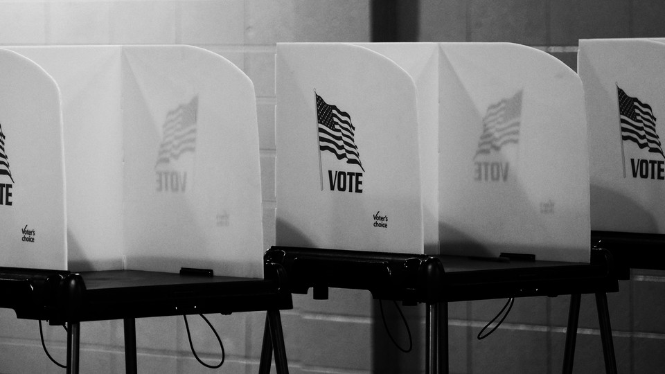 A black-and-white photo of voting booths