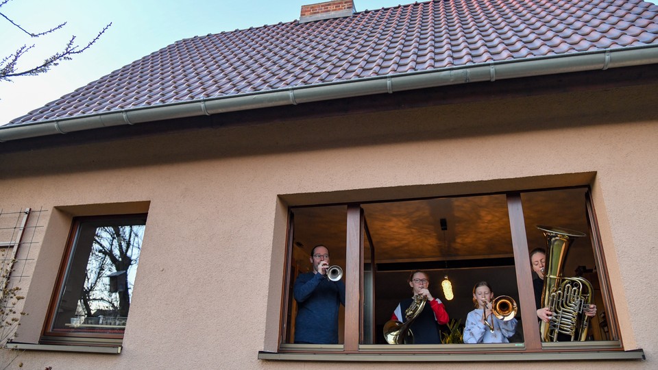 A family in Frankfurt, Germany playing musical instruments together.