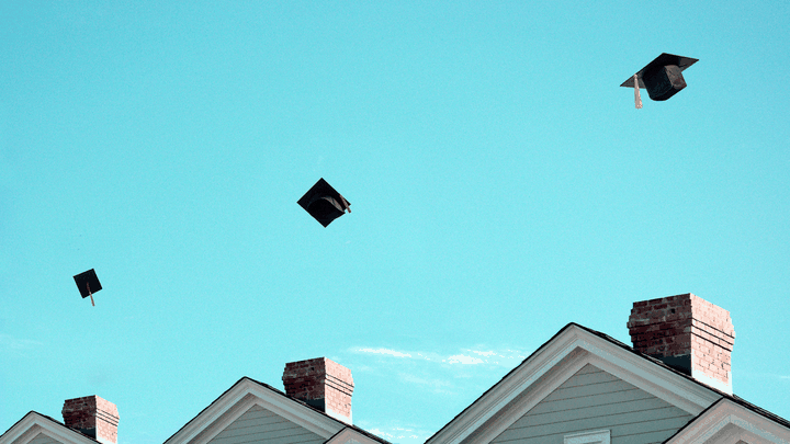 An illustration of graduation caps being thrown above houses.