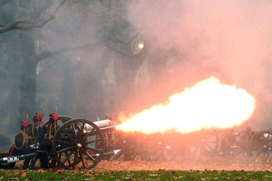 British soldiers in traditional uniforms fire historic cannons.