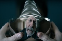 A distorted reflection of a gray-haired person