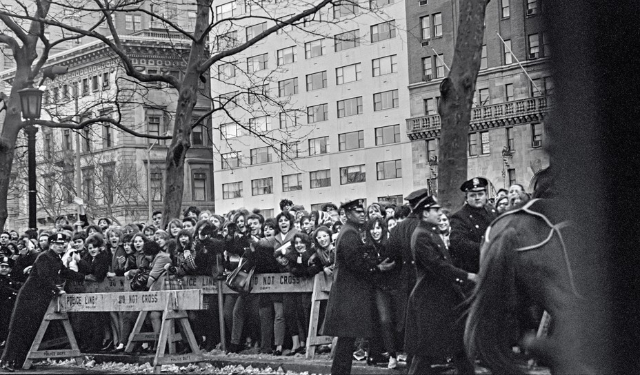 photo of crowds of people behind police barricades