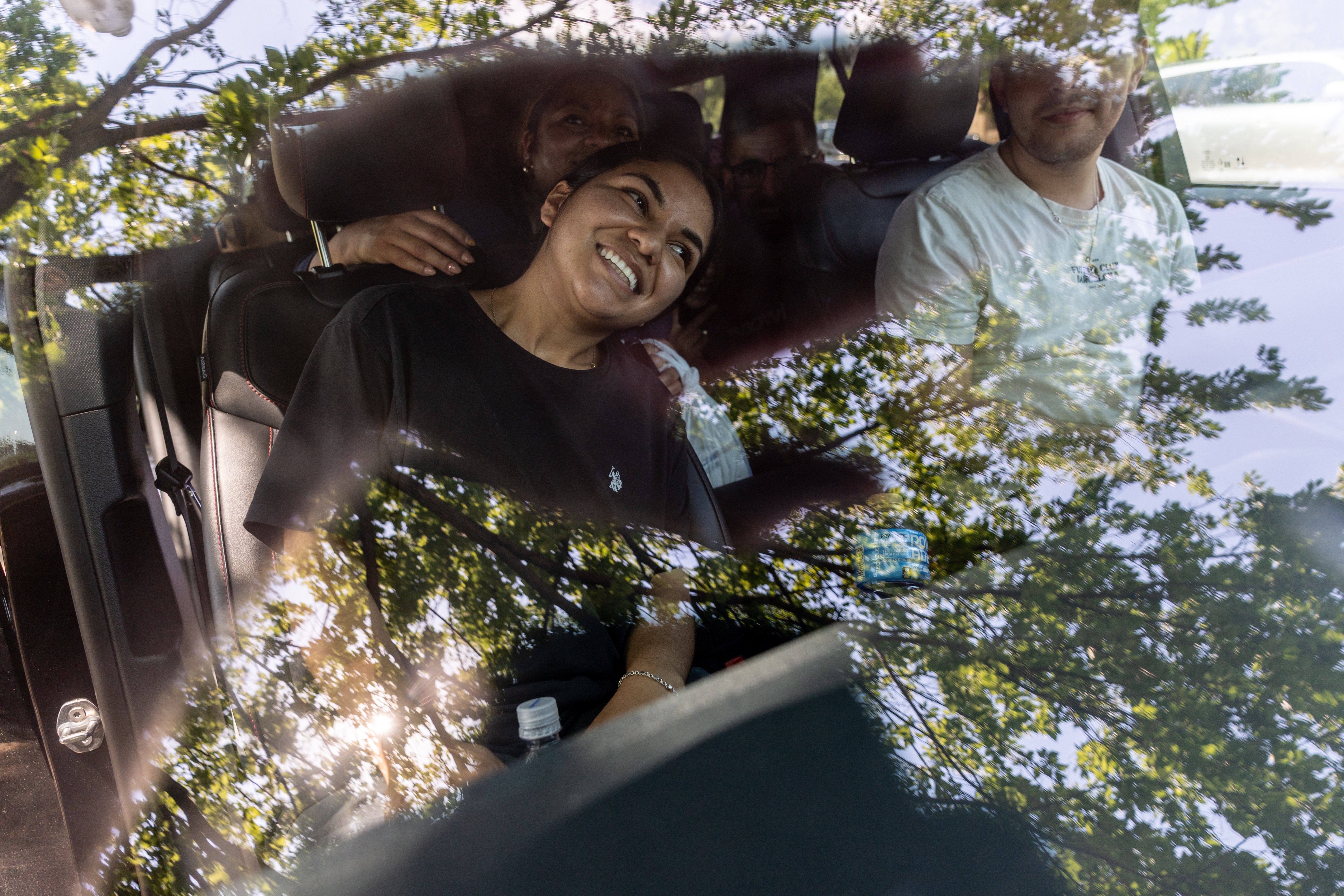 People smile and relax inside a car on a hot day.