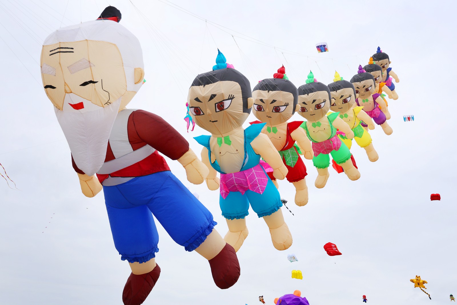 A row of kites, each shaped like a cartoon character.