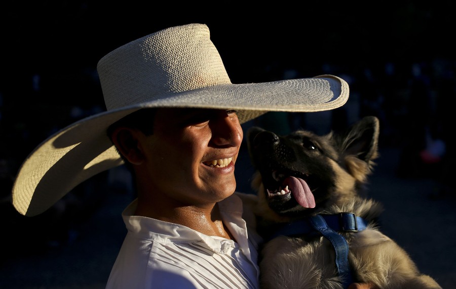 Peruvian Jerry Moya, wears traditional Peruvian "Marinera" clothes as he holds his dog Tom before dancing for tips in the Plaza de Armas in downtown Santiago, Chile, on March 12, 2017.