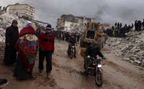 Photo showing Syrian civilians inspecting a destroyed residential building following a 7.8-magnitude earthquake