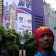 A man with his head wrapped in a Chinese national flag is seen near a building with a partly removed banner advertising an NBA game in Shanghai.