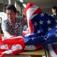 A seamstress sews together an American flag at a factory in Beijing.