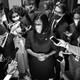 A black-and-white photo of Representative Pramila Jayapal of Washington State surrounded by reporters