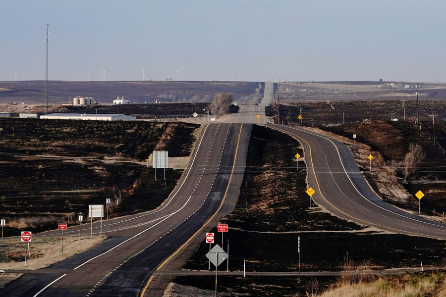 Charred grassland surrounds a highway.