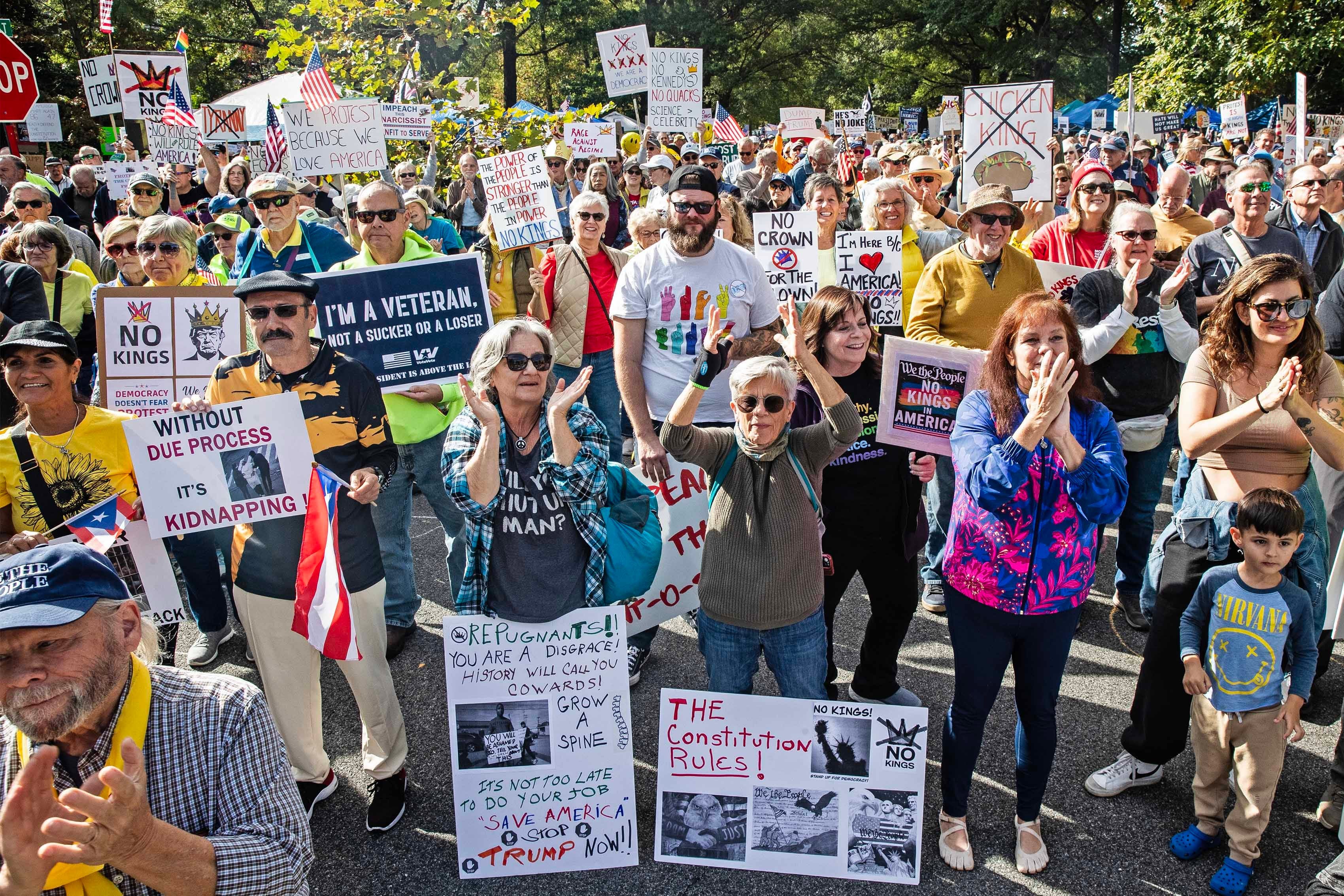 A large group of protesters cheer and hold signs.