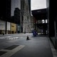 A homeless woman surrounded by luxury stores on 5th Avenue in New York City.
