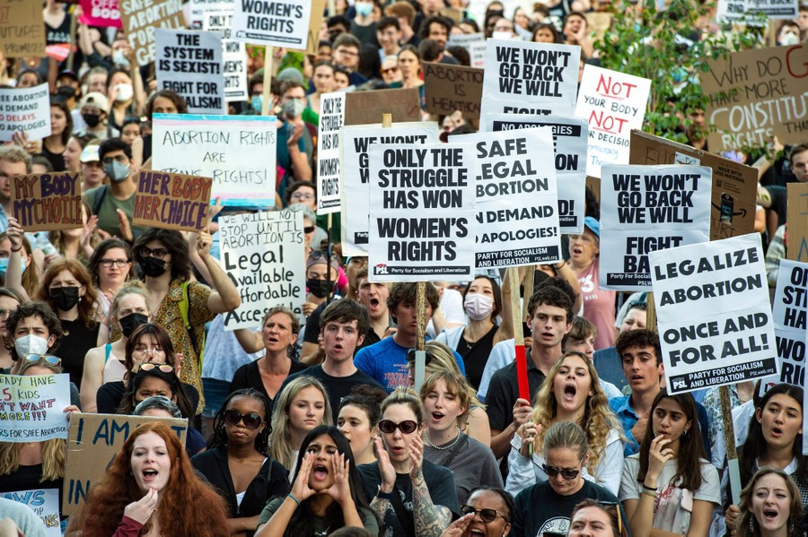 Protesters hold up signs that read "Only the struggle has won women's rights" and "Legalize abortion once and for all."
