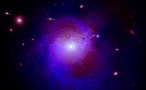 A composite image of the Perseus galaxy cluster, rendered here in bright purple, located 250 million light-years from Earth