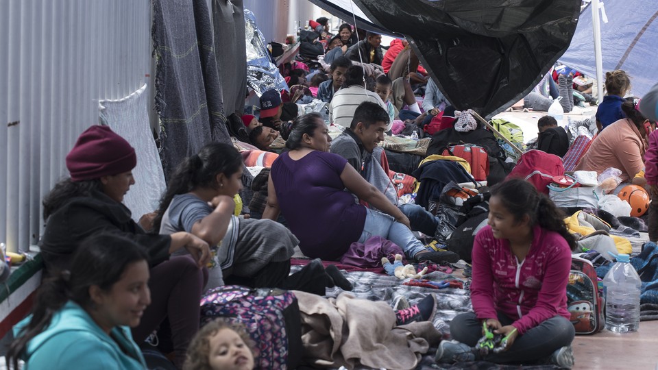 Members of the caravan await entry into the United States