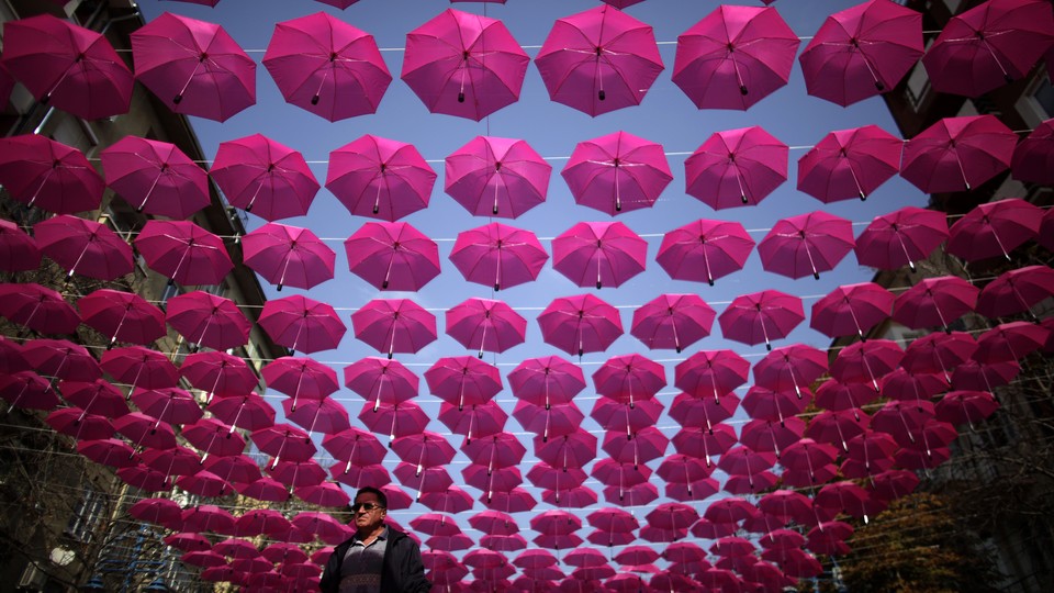 Pink umbrellas strung along a street