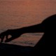 image of a sunset on a lake with a figure in the shadow