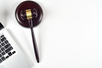 A gavel rests next to a laptop keyboard.