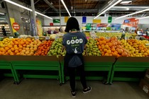 A young woman works in the produce department of a grocery store