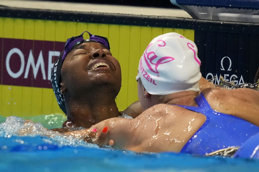 Two swimmers react together in a pool after a race.