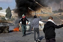 Palestinians use slingshots to throw stones toward Israeli soldiers during a demonstration in Ramallah, the West Bank, on October 18, 2023.