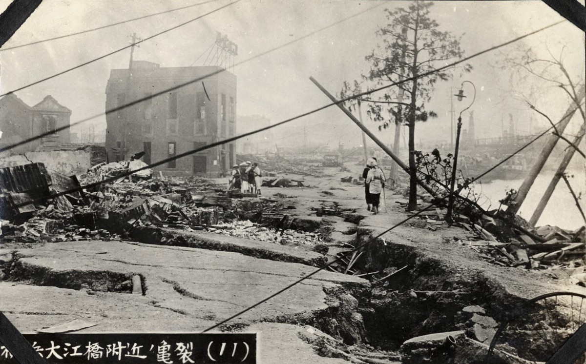 A photo of the aftermath of the Great Kanto Earthquake. People walking along the cracks in the ground.