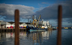 A fishing boat sits at a harbor on Britain's southern coast