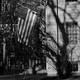 Black-and-white photo of American flag hanging from college building