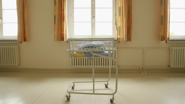 Folded blankets sit atop a cart for newborn babies.