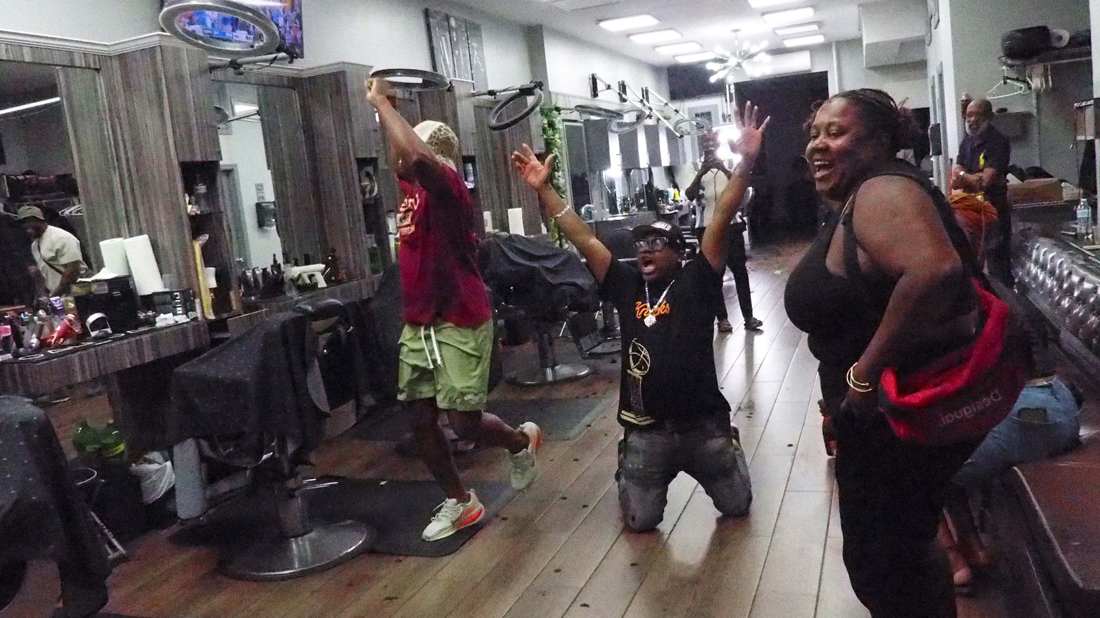 People inside a hair salon celebrate during a watch party for the New York Knicks.