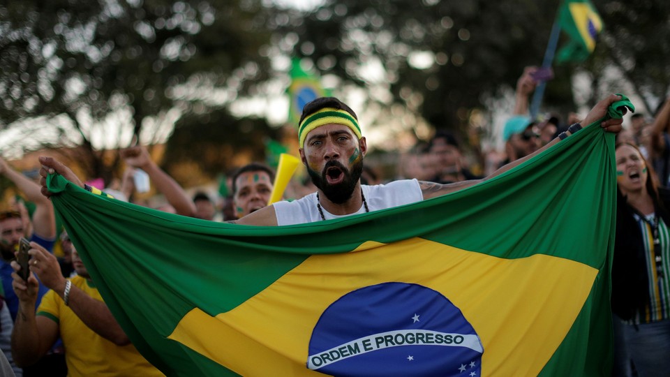 A protester holding a Brazilian flag