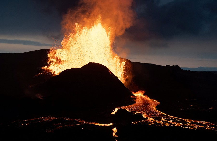A night image of lava erupting from a volcano