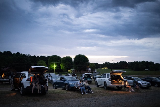 Moviegoers sit at their vehicles at the Badin Road Drive-In Theater, in Badin, North Carolina, on Sunday, May 24, 2020. On Saturday, new North Carolina coronavirus cases spiked to 1,070, a single-day record, as the state moves into phase 2 of reopening over the Memorial Day weekend. 