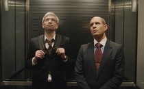 Two men riding in an elevator, staring somewhat skeptically at the ceiling, in "BlackBerry"