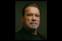 Photo of Arnold Schwarzenegger in dark shirt on green background