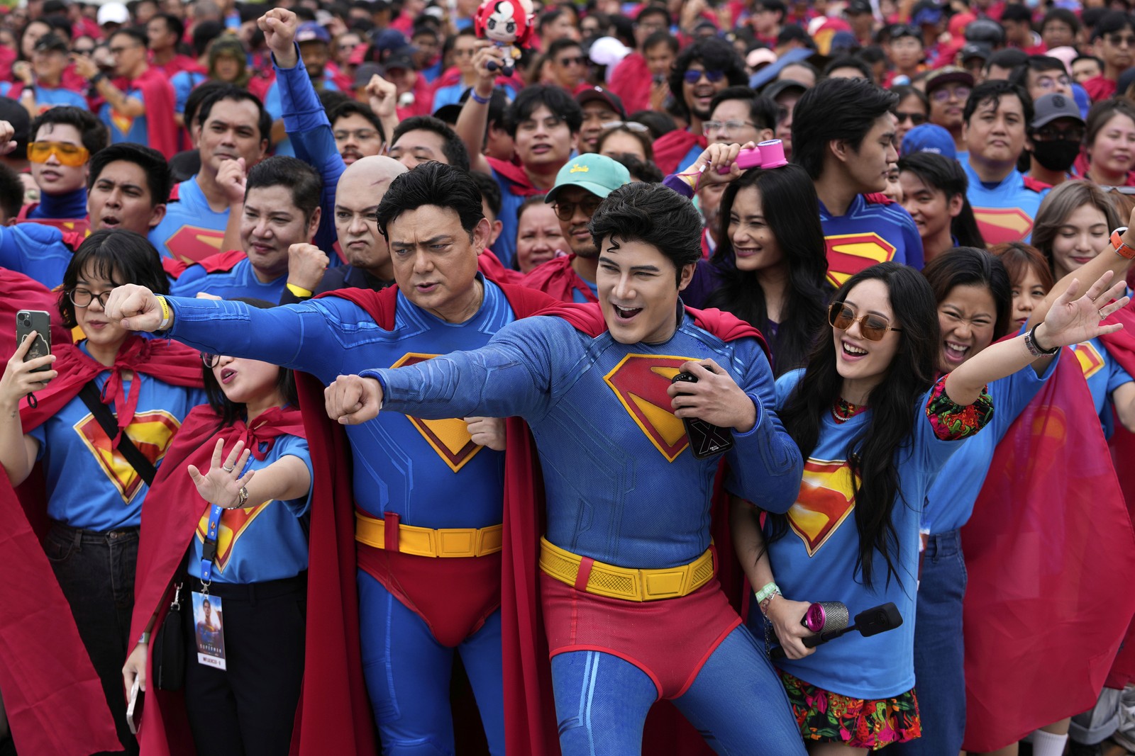 Dozens of people gather together, with many of them wearing Superman costumes.