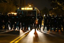 Riot police gather near protesters after a midnight curfew, as demonstrators gather by the police station to protest the police shooting of Keith Scott in Charlotte, North Carolina, U.S., September 24, 2016.