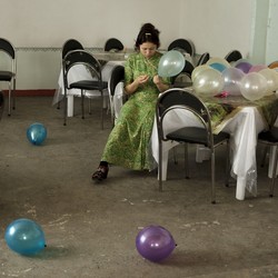 a woman sits at a table with balloons