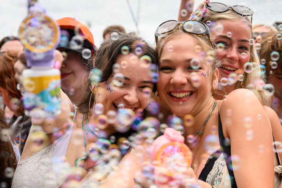 Several festivalgoers blow bubbles and smile for the camera.