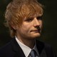 A photo of Ed Sheeran in a suit, looking serious.
