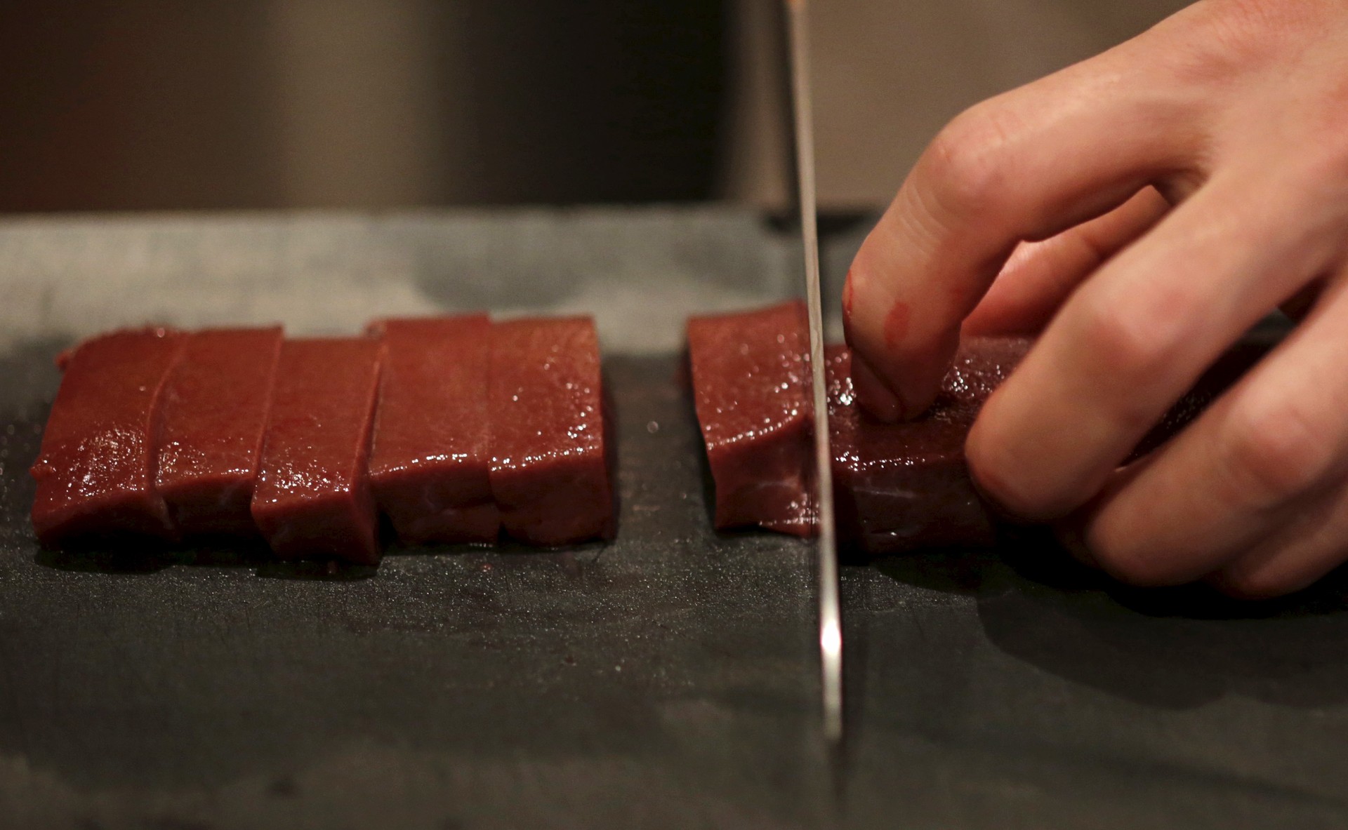 A knife chops a line or raw beef.