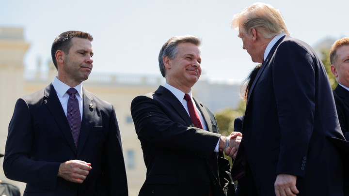 Christopher Wray shakes Donald Trump's hand as Kevin McAleenan looks on.