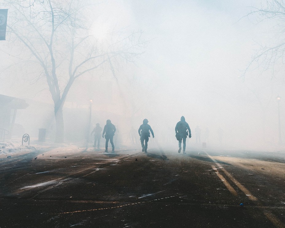 ICE officers are seen in the streets foggy with tear gas