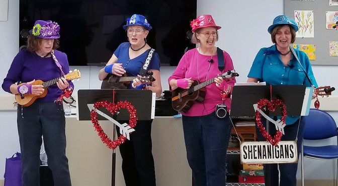 The Shenanigans ukulele band performing in colorful costumes.