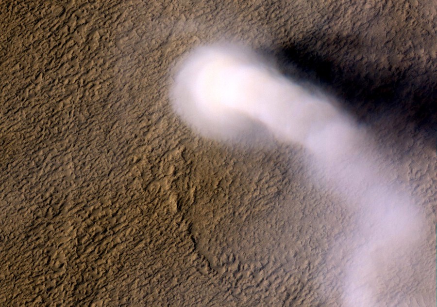 An orbital view of a tall dust devil and a dry Martian surface.