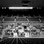 Maricopa County ballots cast in the 2020 general election are examined and recounted in a black-and-white photo of a sports arena.