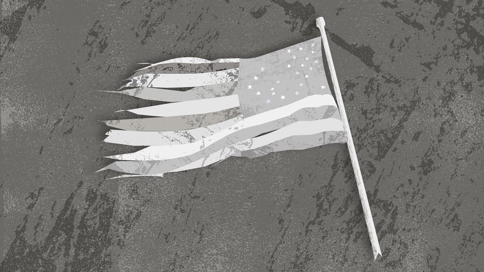 A tattered black-and-white American flag lying on the ground