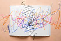 A coloring book covered in multicolor scribbles, as if from crayons